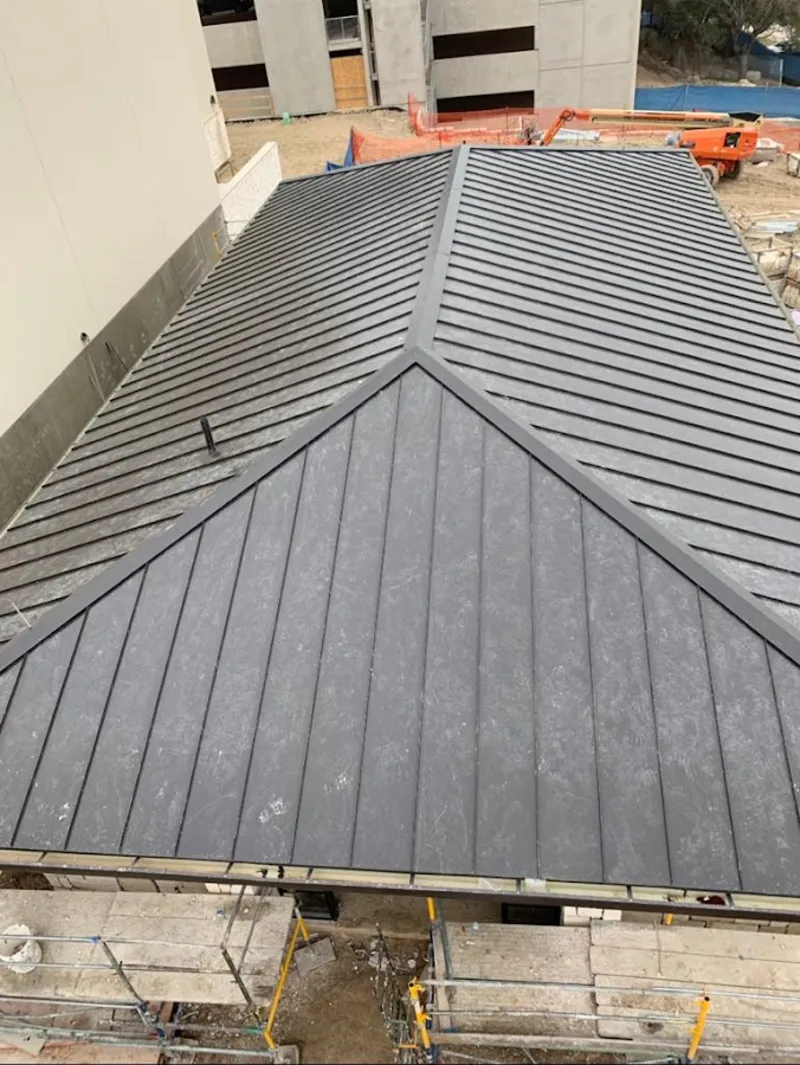 Commercial metal roof construction with crane equipment in Hanford